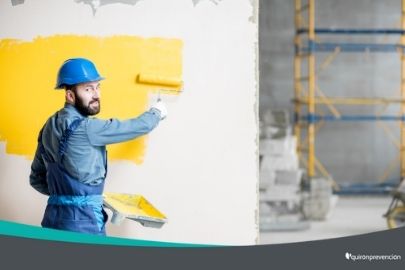 obrero con casco azul pintando pared amarilla imagen pequeña