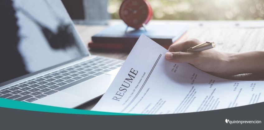 persona sujetando CV con portátil de fondo imagen grande