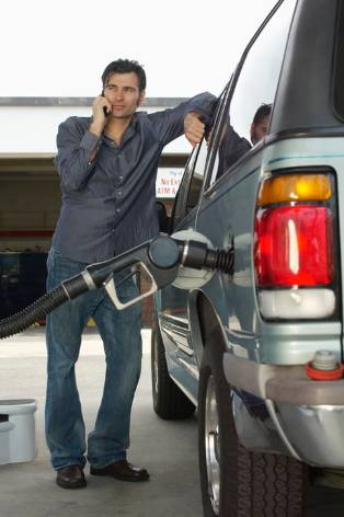 Hombre hablando con móvil en gasolinera (1)