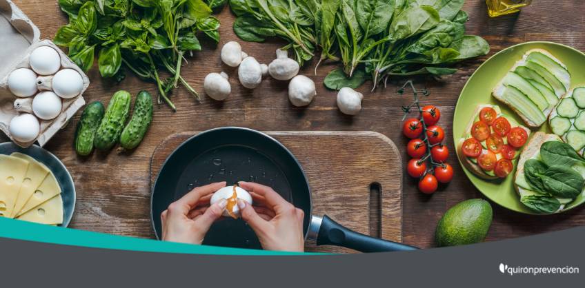 persona cocinando en una mesa repleta de verduras imagen grande