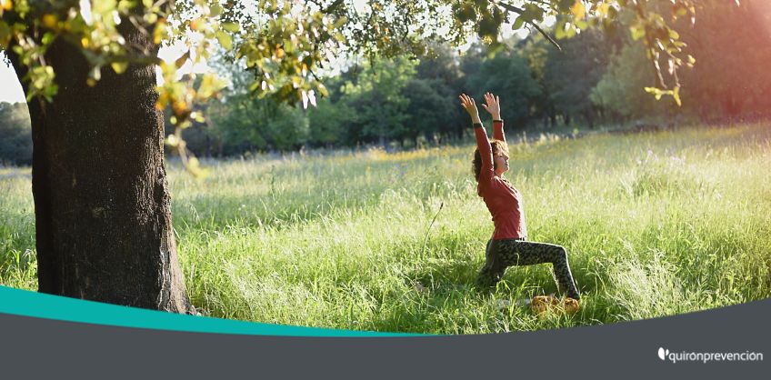 mujer meditando en una pradera verde imagen grande
