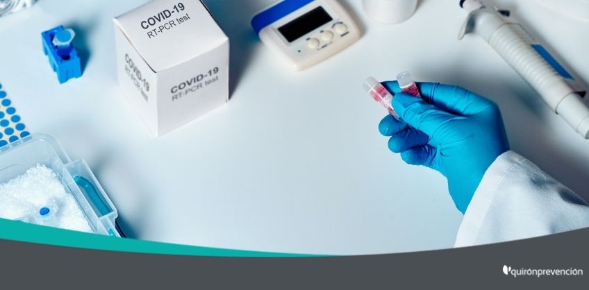persona laboratorio con guantes azules manipulando vacunas covid imagen grande