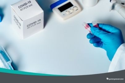 persona laboratorio con guantes azules manipulando vacunas covid imagen pequeña
