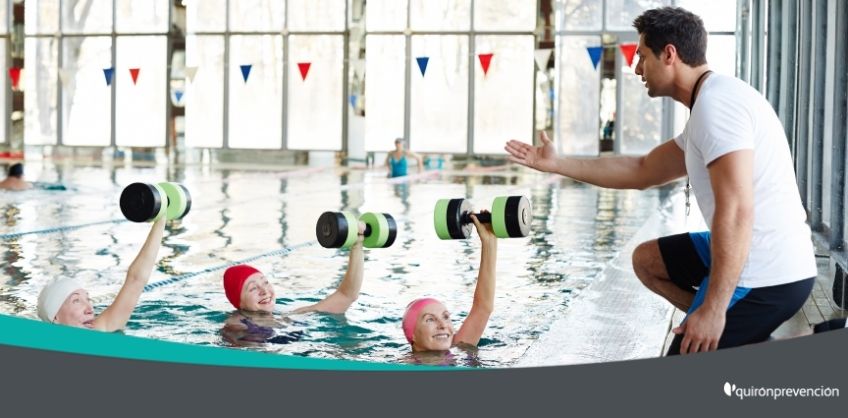 nadadoras de la tercera edad atendiendo al profesor en piscina imagen grande