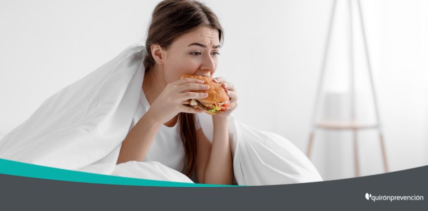 mujer comiendo hamburguesa en la cama imagen_grande