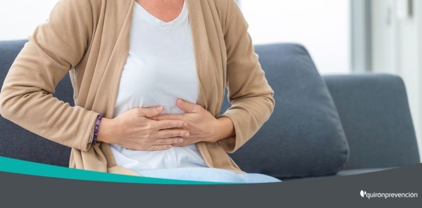 mujer sentada con dolor gastrointestinal imagen grande