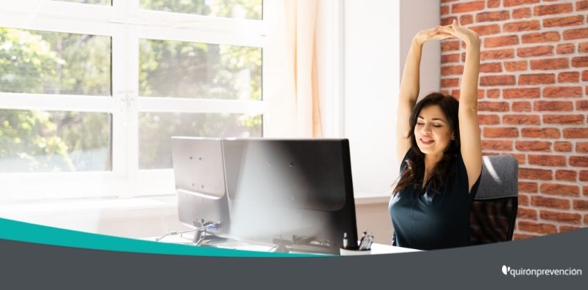 mujer estirándose en escritorio oficina imagen grande
