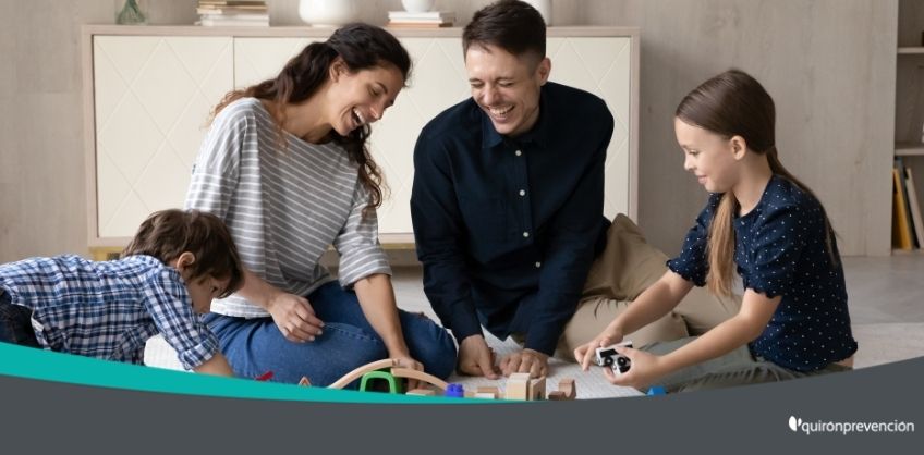 padres jugando con hijos en habitación imagen grande