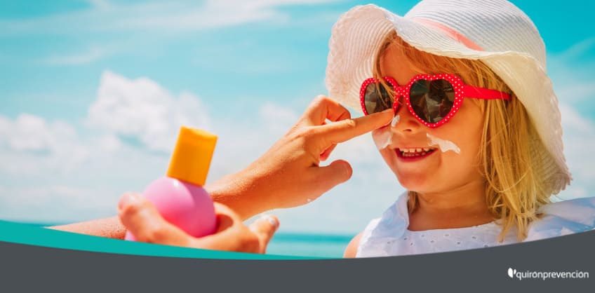 madre poniendo crema solar a niña con gafas de sol imagen grande