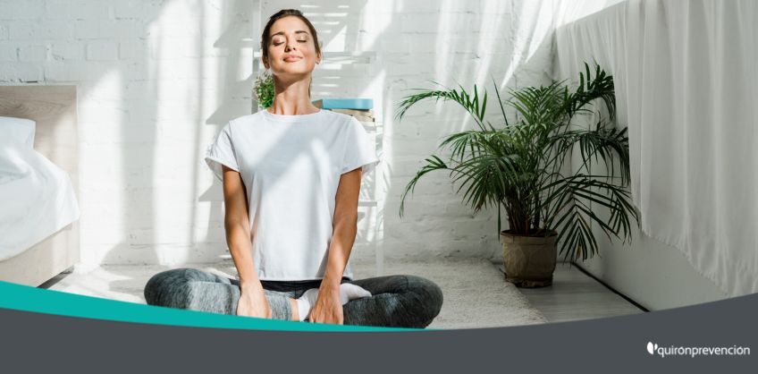 mujer meditando en una habitación con paredes blancas imagen grande