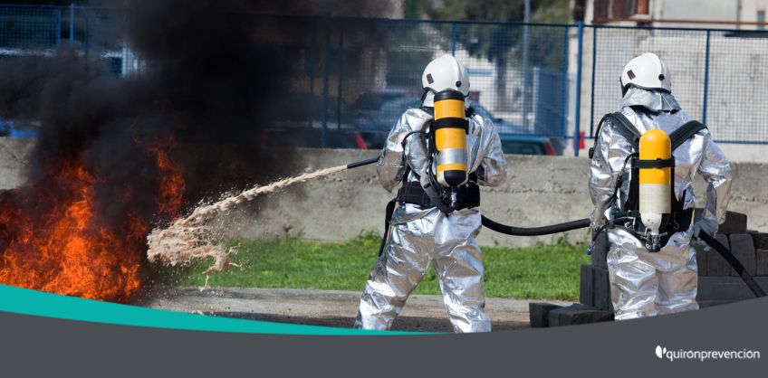 dos bomberos apagando fuego con manguera imagen grande