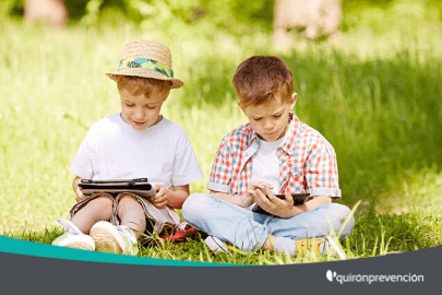 dos niños leyendo en el campo con una tableta imagen pequeña