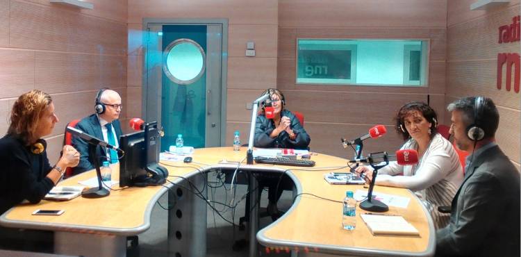 personas sentadas con micrófonos rojo
